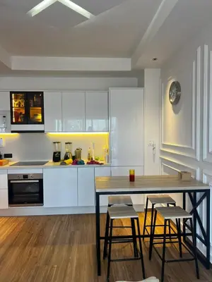 a kitchen with white cabinets and a table and chairs at Chanel home in Marrakech