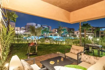 a living room with a couch and a table at Vue Piscine et Golf Luxueux rez de jardin in Marrakech