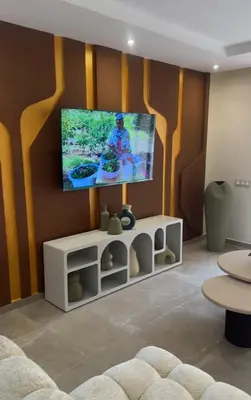 a living room with a flat screen tv on a wall at Appartement coralia in Marrakech