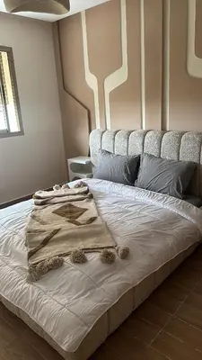 a bed with a blanket on it in a room at Appartement coralia in Marrakech