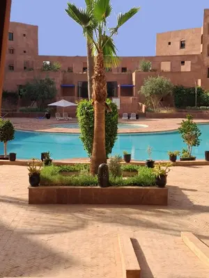 a palm tree in the middle of a courtyard at L'ECRIN de la PALMERAIE in Dar Caïd Layadi