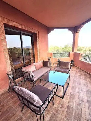 a living room with couches and a glass table at L'ECRIN de la PALMERAIE in Dar Caïd Layadi