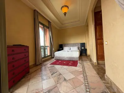 a bedroom with a bed and a red dresser at la palmeraie village 3 in Marrakech