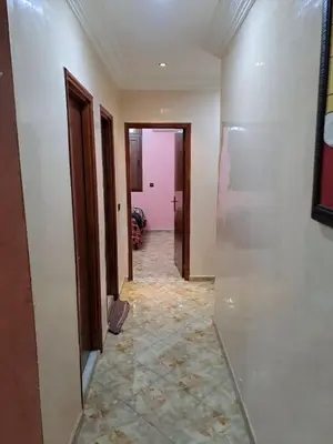 a hallway of a room with white walls and a tile floor at Sweet home in Marrakech