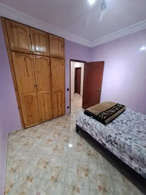 a bedroom with a bed and wooden cabinets at Sweet home in Marrakech