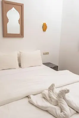 a white bed with a blanket laying on the floor at Refuge blanc terrasse priveee a cite de Majorelle in Marrakech