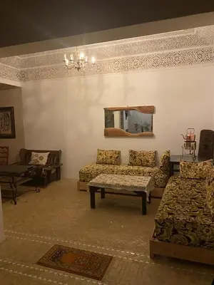 a living room with couches and a table and a mirror at Riad khalid zrika in Marrakech