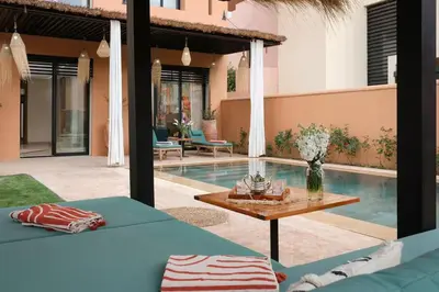 a patio with a table and a swimming pool at Riad Beldi Chic Golf Al Maaden in Marrakech