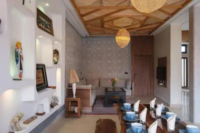 a living room with a table and chairs and a couch at Riad Beldi Chic Golf Al Maaden in Marrakech