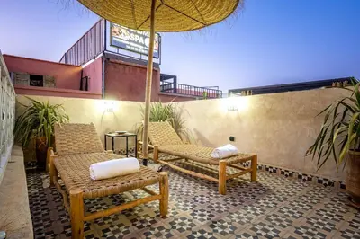 a patio with two chairs and an umbrella at Riad Ryme-Newly renovated-Exclusive-Free breakfast in Marrakech
