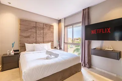 a hotel room with a bed with a netflix sign on the wall at Opulent 3BR apartment, pool view in Marrakech