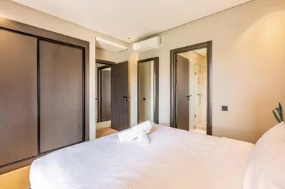 a bedroom with a large white bed and a mirror at Opulent 3BR apartment, pool view in Marrakech