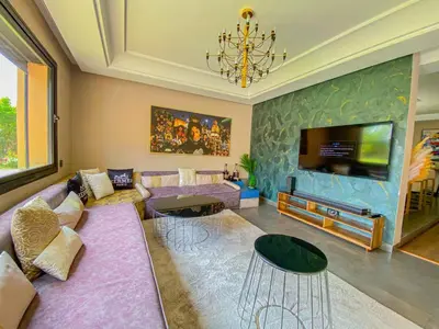 a living room with a couch and a tv at villas route d amzmiz in Marrakech