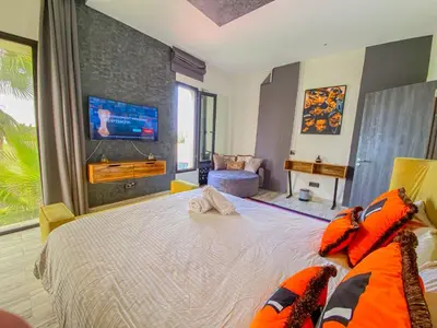 a bedroom with a large bed with a tv on the wall at villas route d amzmiz in Marrakech