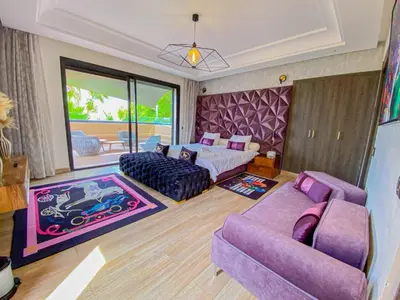 a bedroom with a purple bed and a couch at villas route d amzmiz in Marrakech