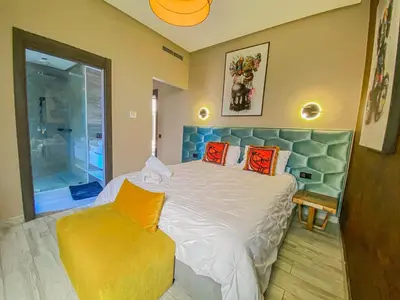 a bedroom with a large bed and a yellow chair at villas route d amzmiz in Marrakech