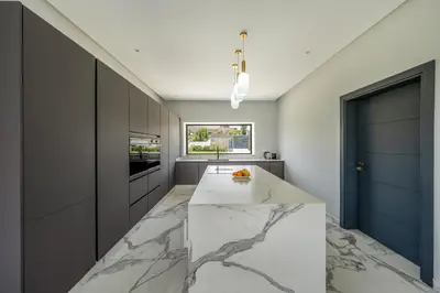a kitchen with a marble counter and a blue door at Villa Arbia - Piscine - 5BDR - Fitness - Ping-Pong in Sraghna
