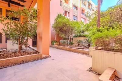 a courtyard of a building with trees and plants at Stylish Apartment with Terrace Central Marrakech in Marrakech