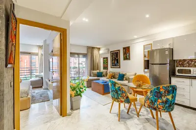 a kitchen and living room with a table and chairs at PB16 Flat Fully Equipped Guéliz TOP Center in Marrakech