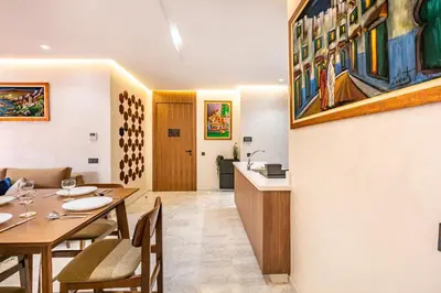 a dining room with a table and a kitchen at HS14 Luxury 2Chambres Gueliz TopCenter in Marrakech