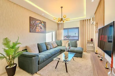 a living room with a blue couch and a tv at GUELIZ city center Perfect location with nice view in Marrakech
