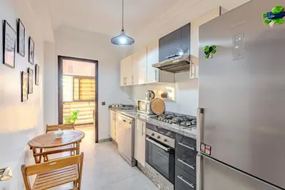 a kitchen with a stainless steel refrigerator and a table at GUELIZ city center Perfect location with nice view in Marrakech