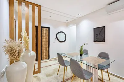 a dining room with a glass table and chairs at Manahil Modern Apartment Gueliz City Center in Marrakech