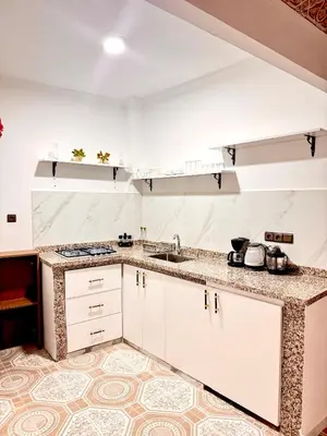 a kitchen with white cabinets and a tile floor at Lalla Mama medina house in Marrakech