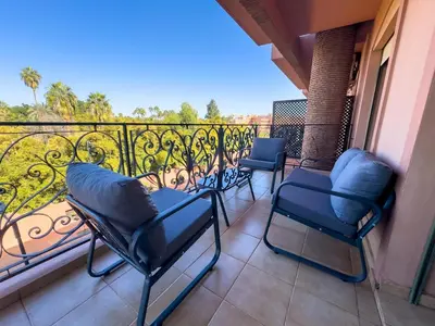 a balcony with four chairs and a balcony railing at Majorelle Apartment - Terrace Stunning Garden View in Marrakech