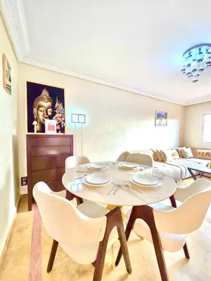 a living room with a table and chairs and a couch at Joli et chic Appartement à Marrakech - balcon privé et confort in Oulad Akkou