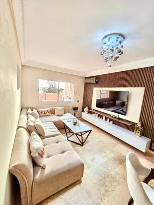 a large living room with a couch and a fireplace at Joli et chic Appartement à Marrakech - balcon privé et confort in Oulad Akkou