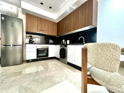 a kitchen with stainless steel appliances and a chair at Résidence Ménara Garden Proche Gare & Jardins Ménara in Marrakech