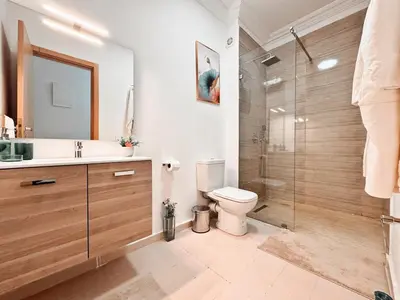 a bathroom with a toilet and a glass shower at Appartement calme et ensoleillé avec piscine in Marrakech