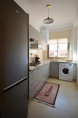 a kitchen with a washer and dryer in it at Appartement calme et ensoleillé avec piscine in Marrakech