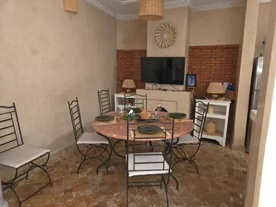 a dining room with a table and chairs and a television at Authentic Riad & Jacuzzi in Marrakech