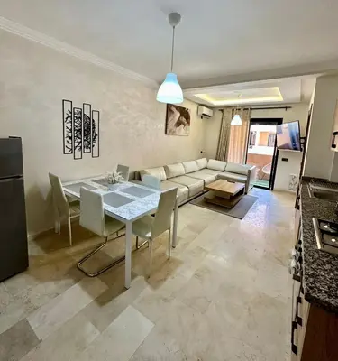 a living room with a table and a couch at Moderne appartement centre Marrakech in Marrakech