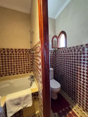 a bathroom with a toilet and a bath tub at Luxury Private Riad, Air-Conditioned and Pool in Marrakech