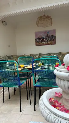 a dining room with blue chairs and a table with a fountain at Riad Privatisé- Riad Dar Farida in Marrakech