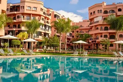 a hotel with a swimming pool in front of a building at Luxe et sérénité avec jardin, terrasse et 5 piscines in Marrakech