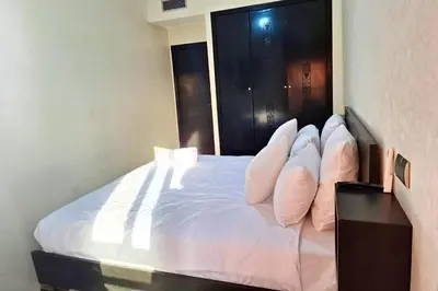 a bedroom with a bed with white sheets and pillows at Luxe et sérénité avec jardin, terrasse et 5 piscines in Marrakech