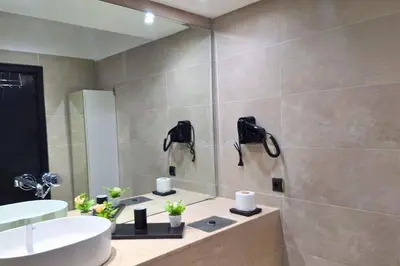 a bathroom with a sink and a tub and a shower at Luxe et sérénité avec jardin, terrasse et 5 piscines in Marrakech