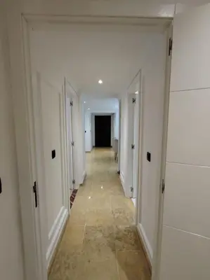 a hallway with white walls and a long hallway with doors at Majorelle Prestige in Marrakech