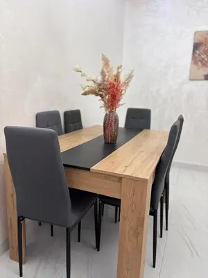 a wooden table with chairs and a vase with flowers at La citrine in Marrakech