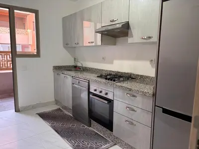 a kitchen with a stove and a refrigerator at La citrine in Marrakech
