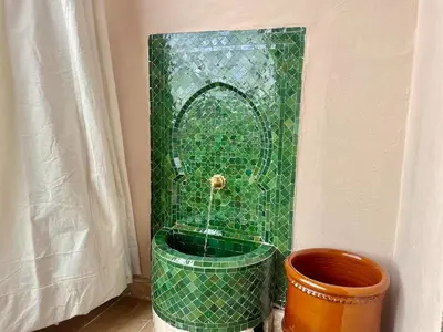 a green tiled shower with a fountain in a room at Gueliz Terracotta Stay - 2 BR & Cozy Balcony in Marrakech