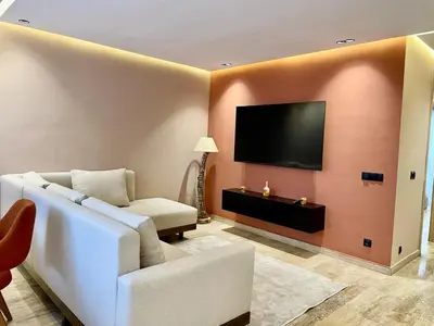 a living room with a couch and a flat screen tv at Gueliz Terracotta Stay - 2 BR & Cozy Balcony in Marrakech