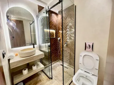 a bathroom with a toilet and a glass shower at Gueliz Terracotta Stay - 2 BR & Cozy Balcony in Marrakech