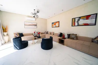 a living room with a couch and two blue chairs at Viva La Villa in Marrakech