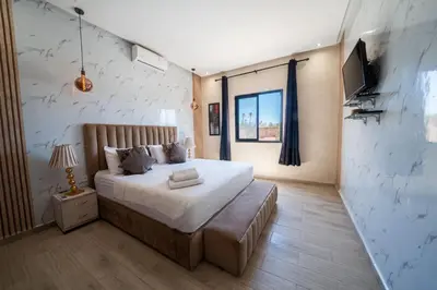 a bedroom with a bed and a television in it at Viva La Villa in Marrakech