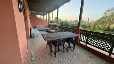 a porch with a table and chairs on a balcony at Luxury apartement Palmeraie Village in Marrakech